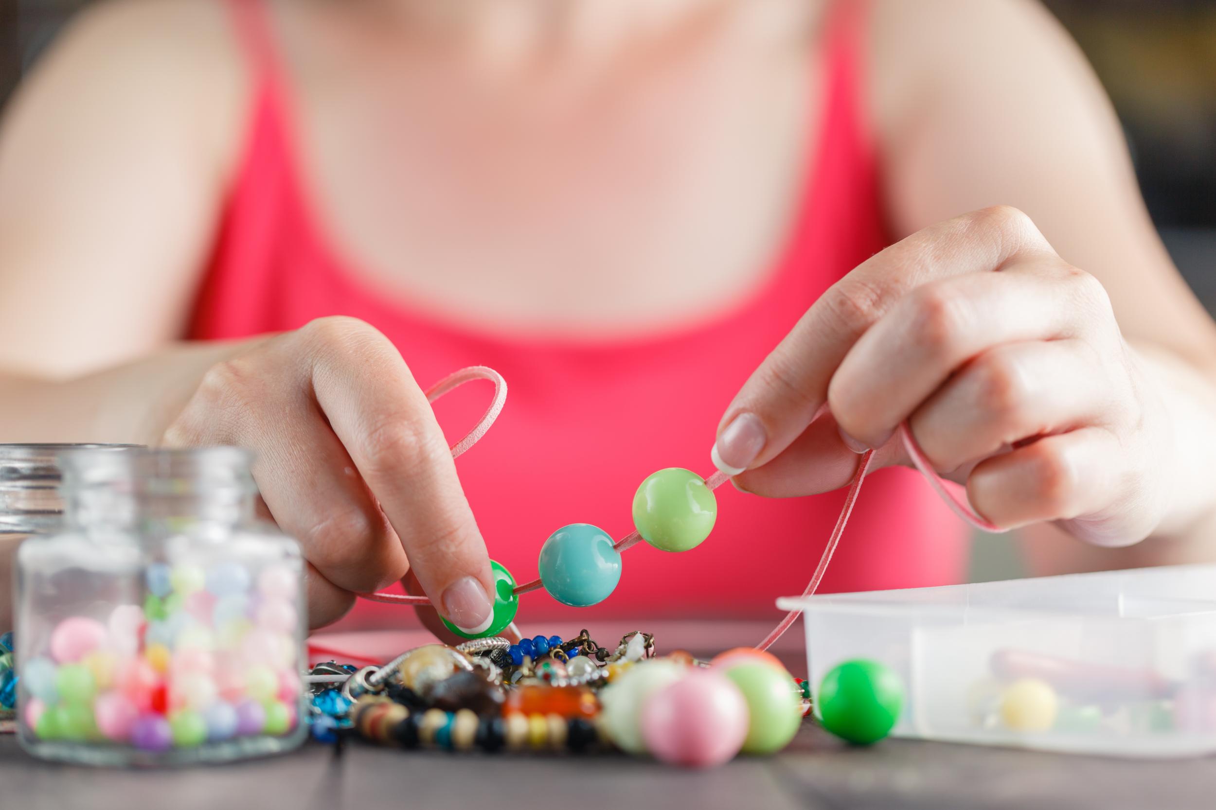 young girl making bracelets